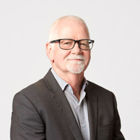 A professional man in a suit jacket and glasses, showcasing a polished and sophisticated appearance.