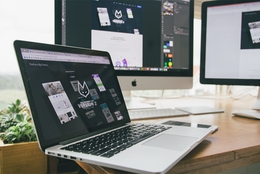 A Graphic Designer's workstation with computer and screens