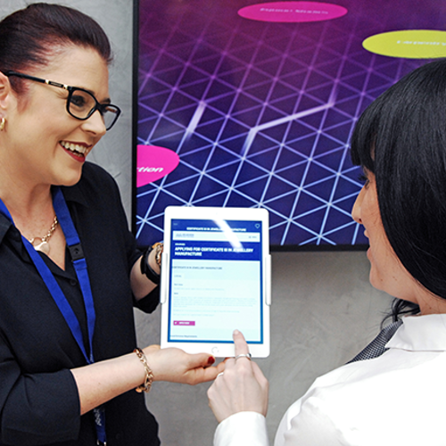 Melbourne Polytechnic staff member showing student how to fill out form on android device