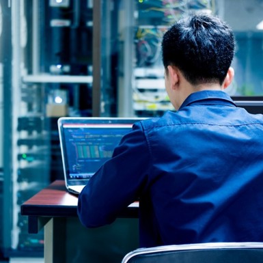 Man sitting at computer writing code