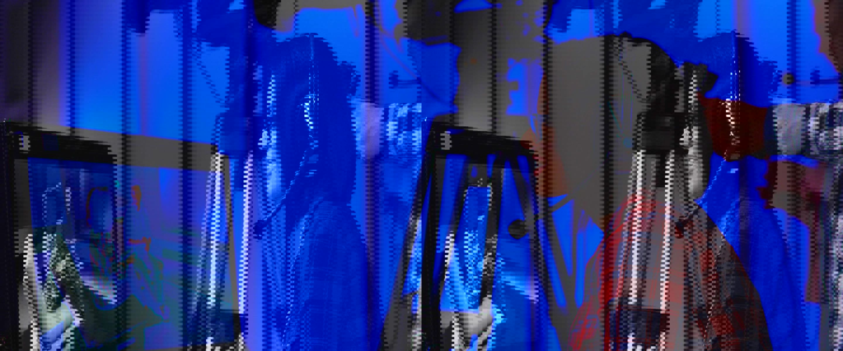 A woman looking into a tv monitor with a camera operator in the background