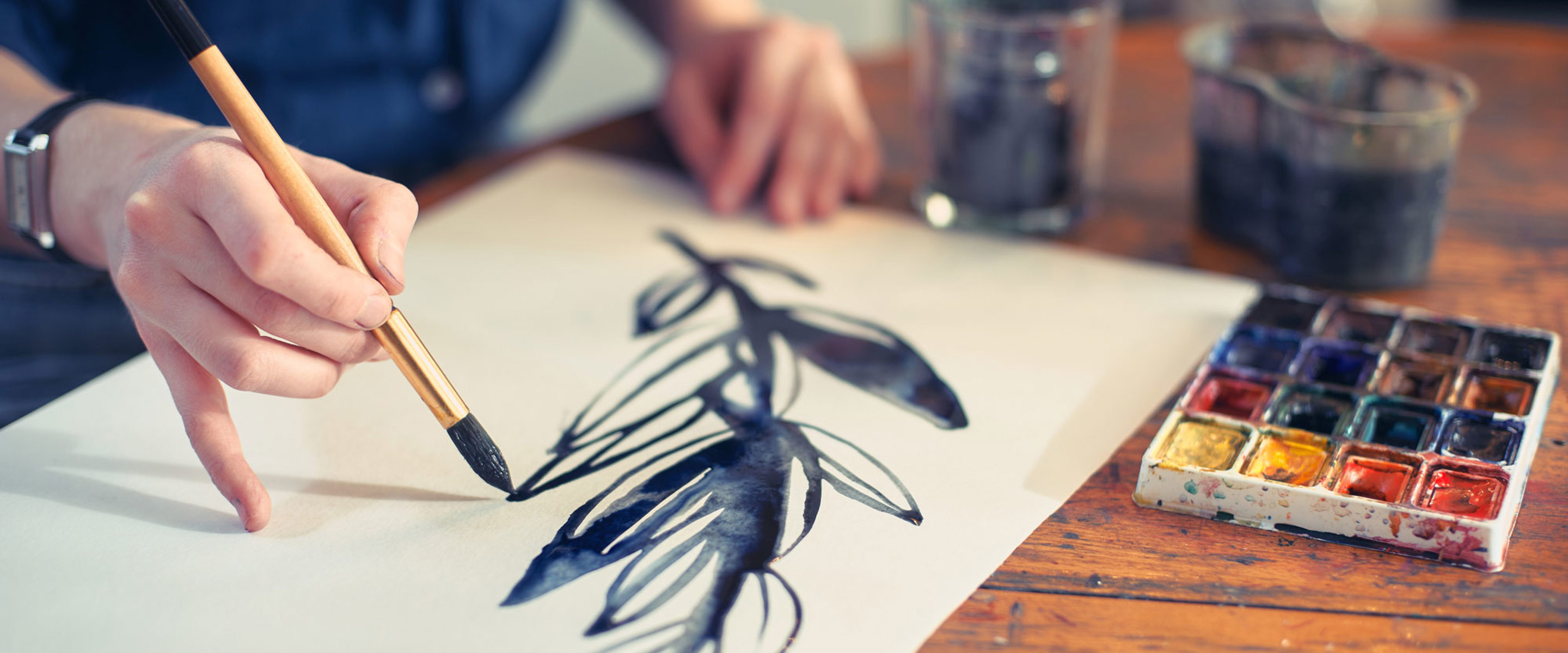 A leafy branch being painted on a blank canvas