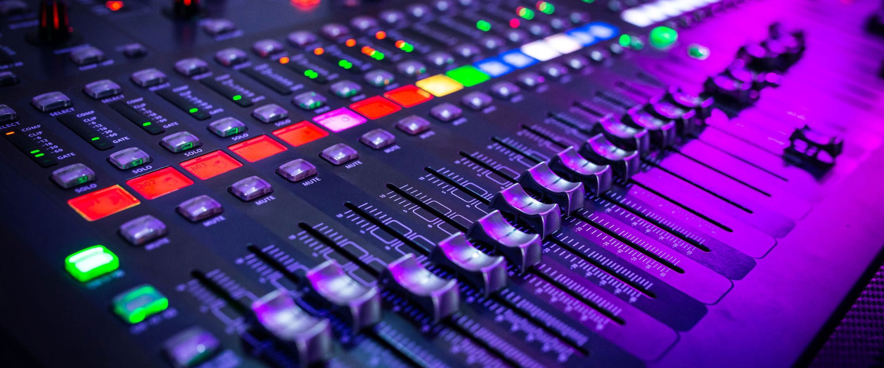 A control panel sound board with an array of buttons and controls 