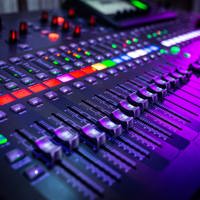 A control panel sound board with an array of buttons and controls 