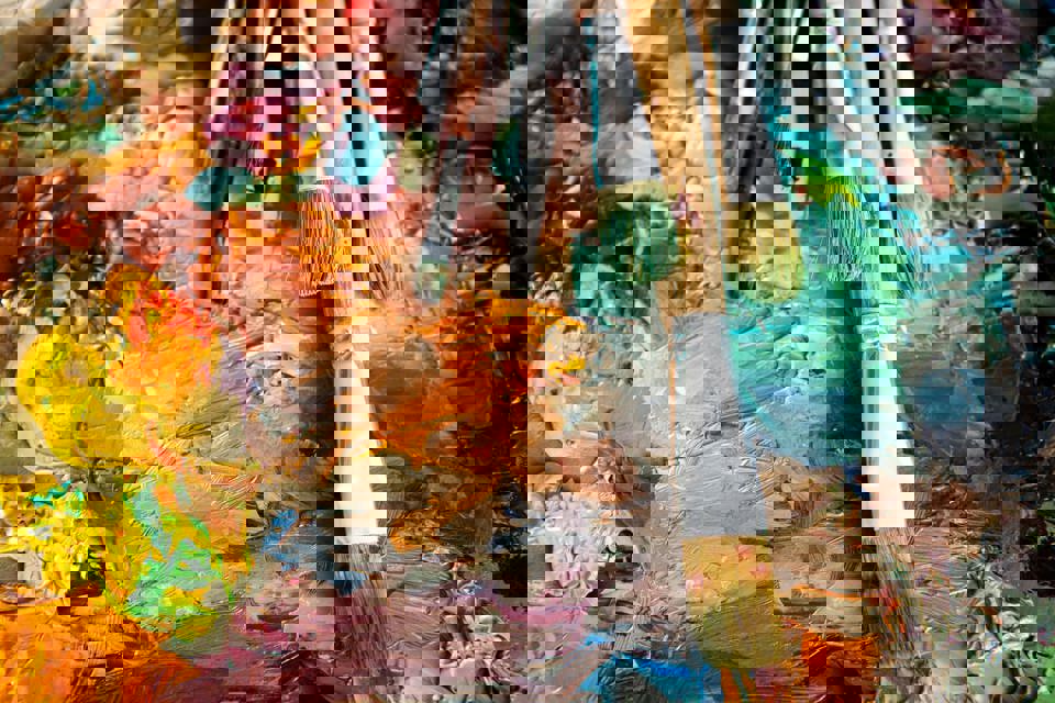 Different sized paint brushes lying on top of an abstract painting