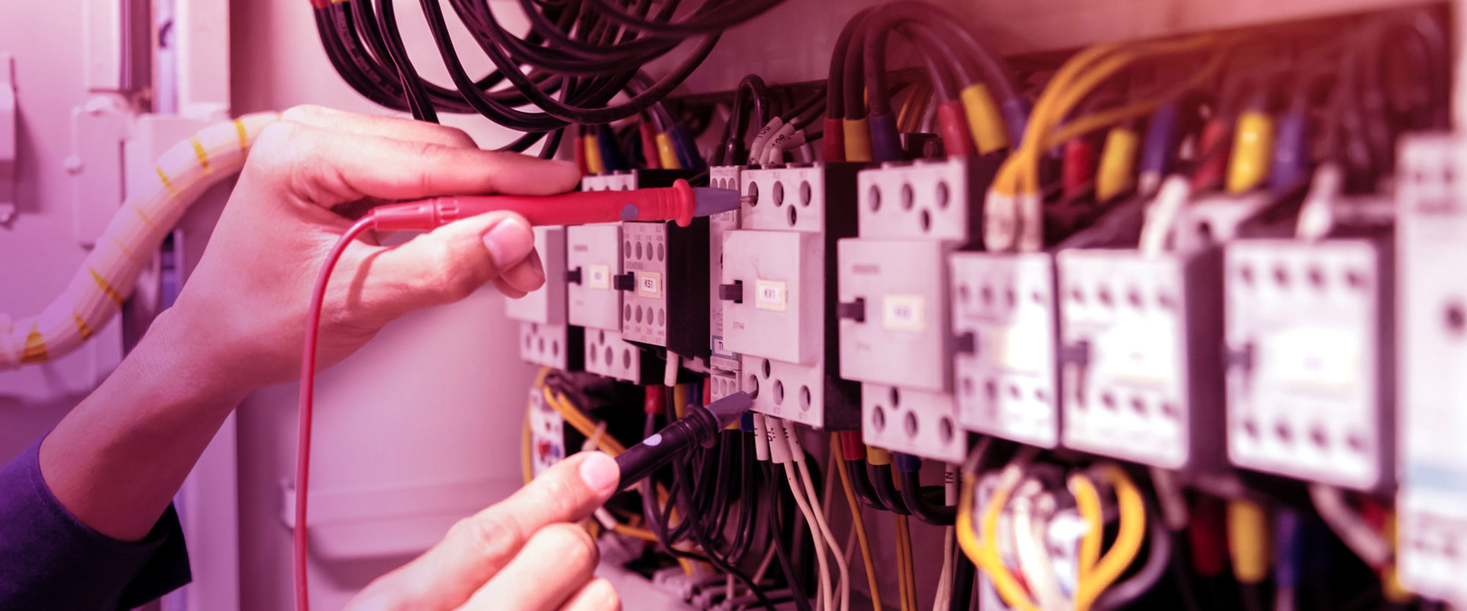 An electrician connecting cables to an electricity box