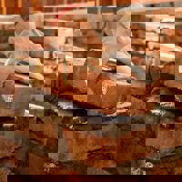 A person laying a brick on top of some mortar