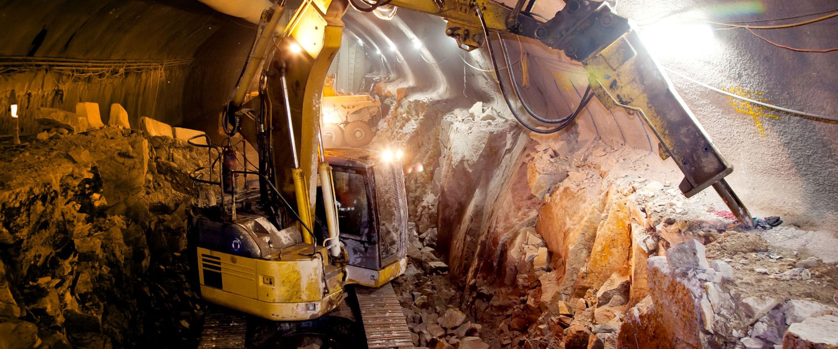 Heavy vehicle machinery inside a tunnel drilling to create room. Used in engineering.