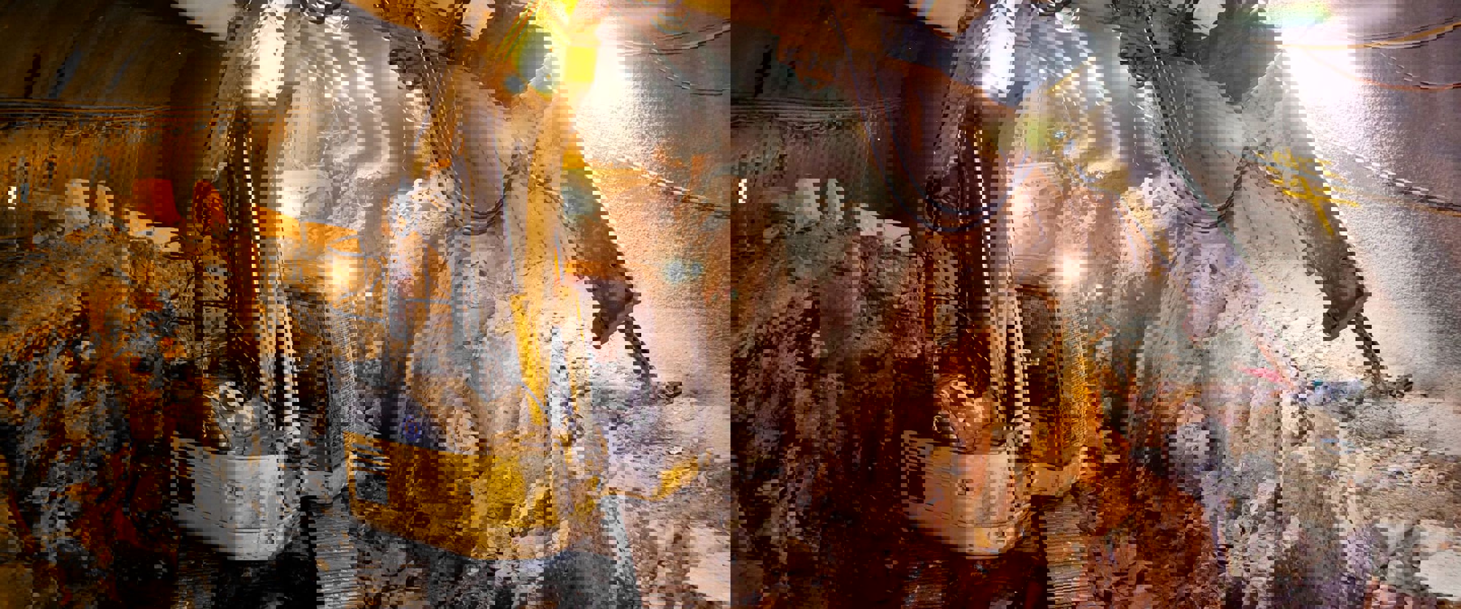 Heavy vehicle machinery inside a tunnel drilling to create room. Used in engineering.