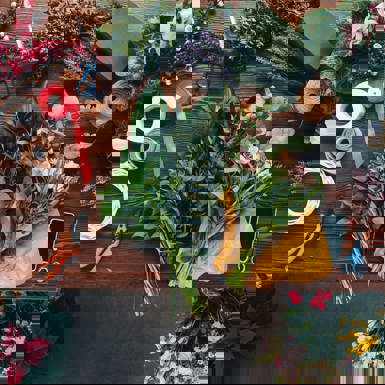 A bird's-eye view of flowers being trimmed and tied together for a bouquet 