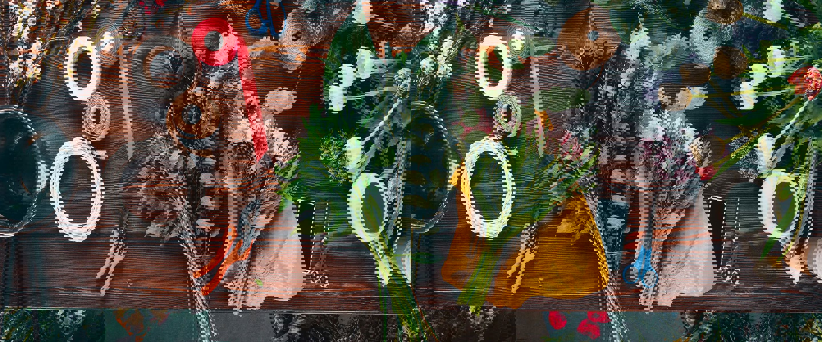 A bird's-eye view of flowers being trimmed and tied together for a bouquet