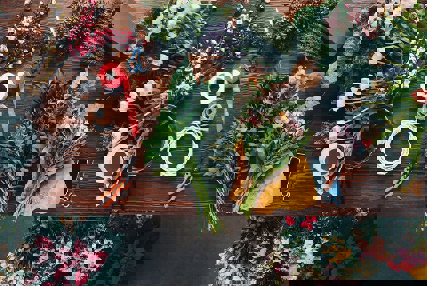 A bird's-eye view of flowers being trimmed and tied together for a bouquet