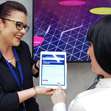 Staff member holding an electronic tablet with application information.