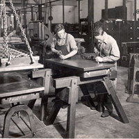 Two people working on wooden table in 1940