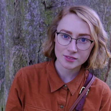 Student Amanda leaning against a tree