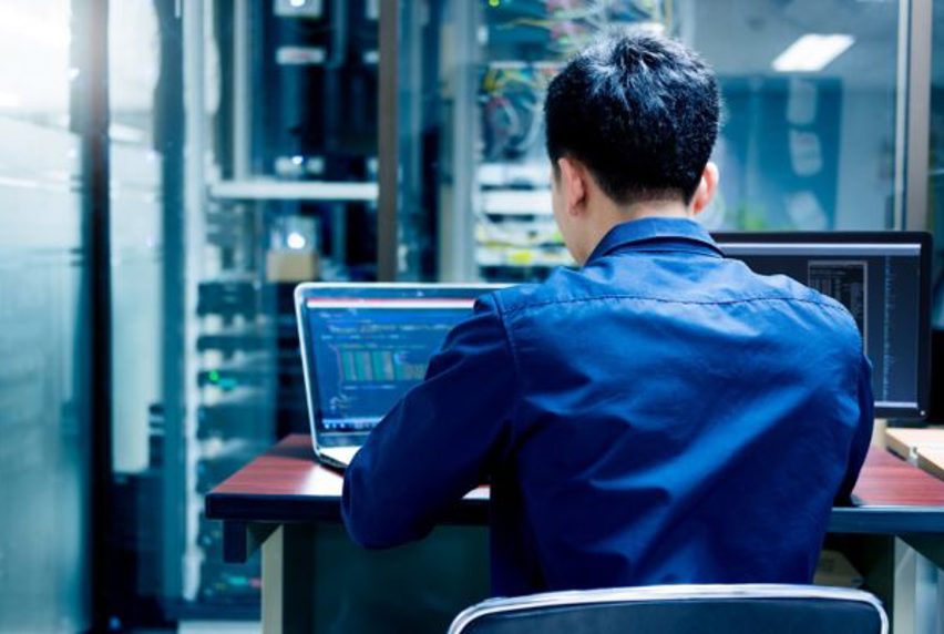 Man sitting a computer writing code