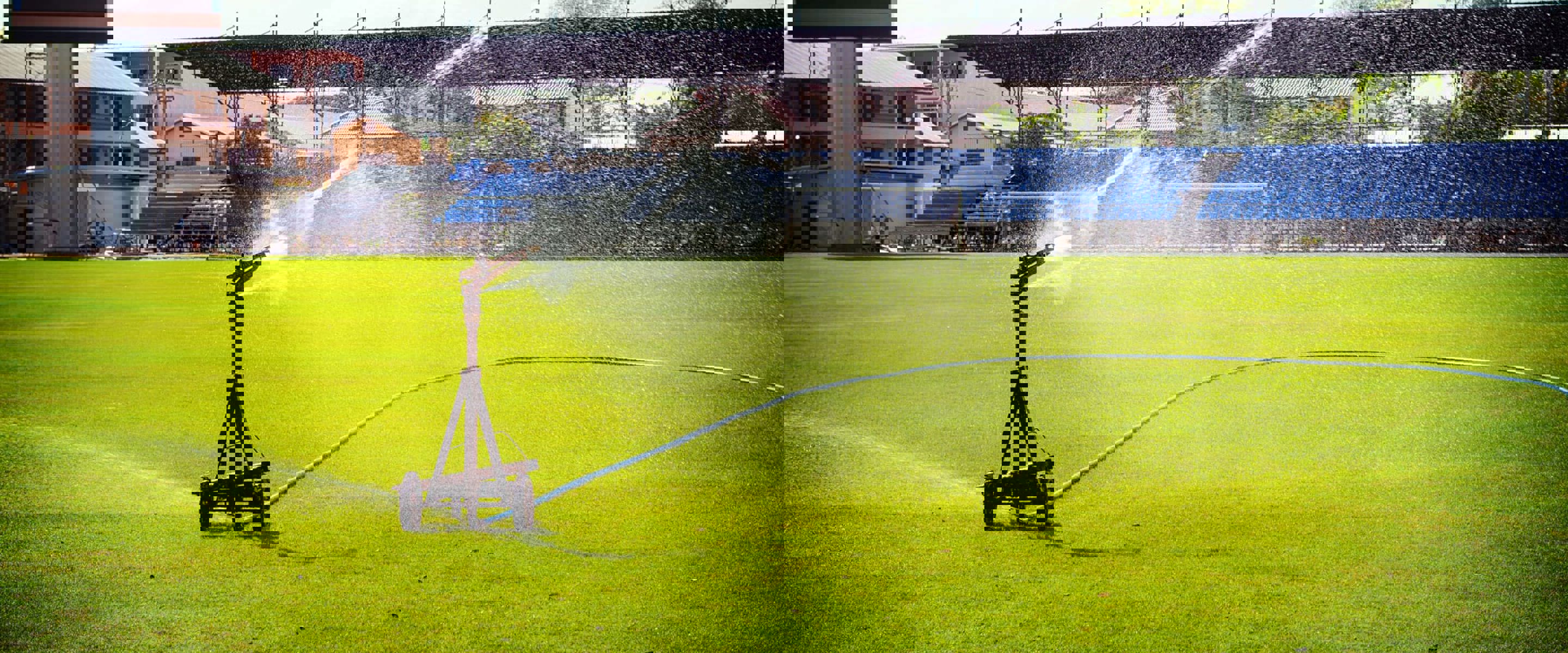 A water sprinkler watering a sporting field