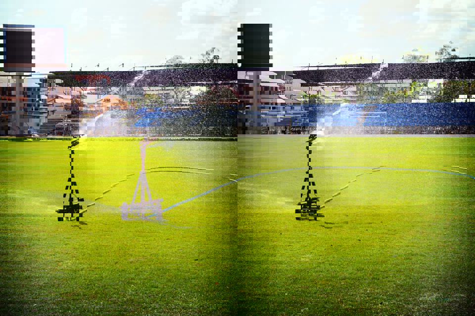 A water sprinkler watering a sporting field