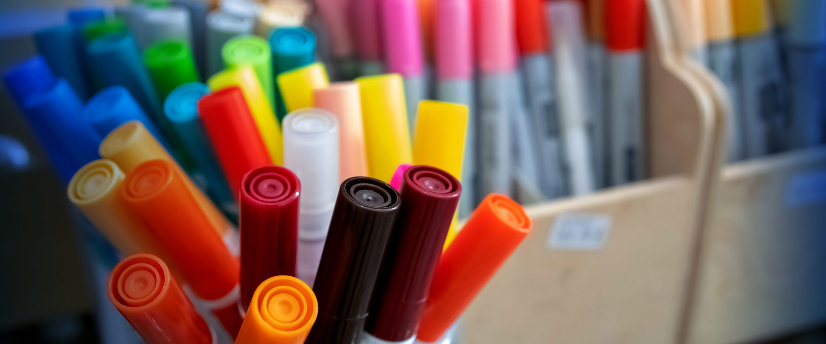 A large selection of coloured textas and sharpies in boxes and jars