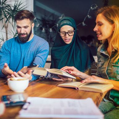People sitting around a table reading and discussing a particular book
