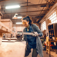 A person cutting wood in a vice