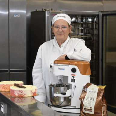 Julie Harris standing behind two cakes with intricate patterns