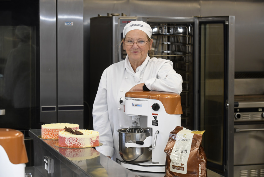 Julie Harris standing behind two cakes with intricate patterns