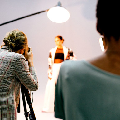 A photographer taking photos of a model at a photo shoot 
