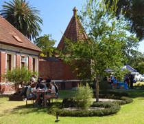 Students sitting outside in the sun on picnic bench eating and socialising at Fairfield campus