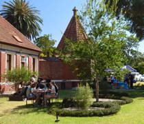 Students sitting outside in the sun on picnic bench eating and socialising at Fairfield campus