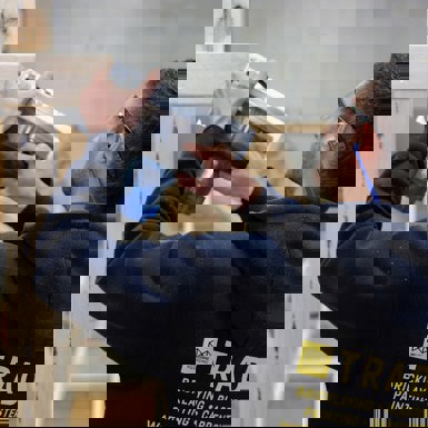 Building Surveying and Construction student with using a hand saw on a timber frame