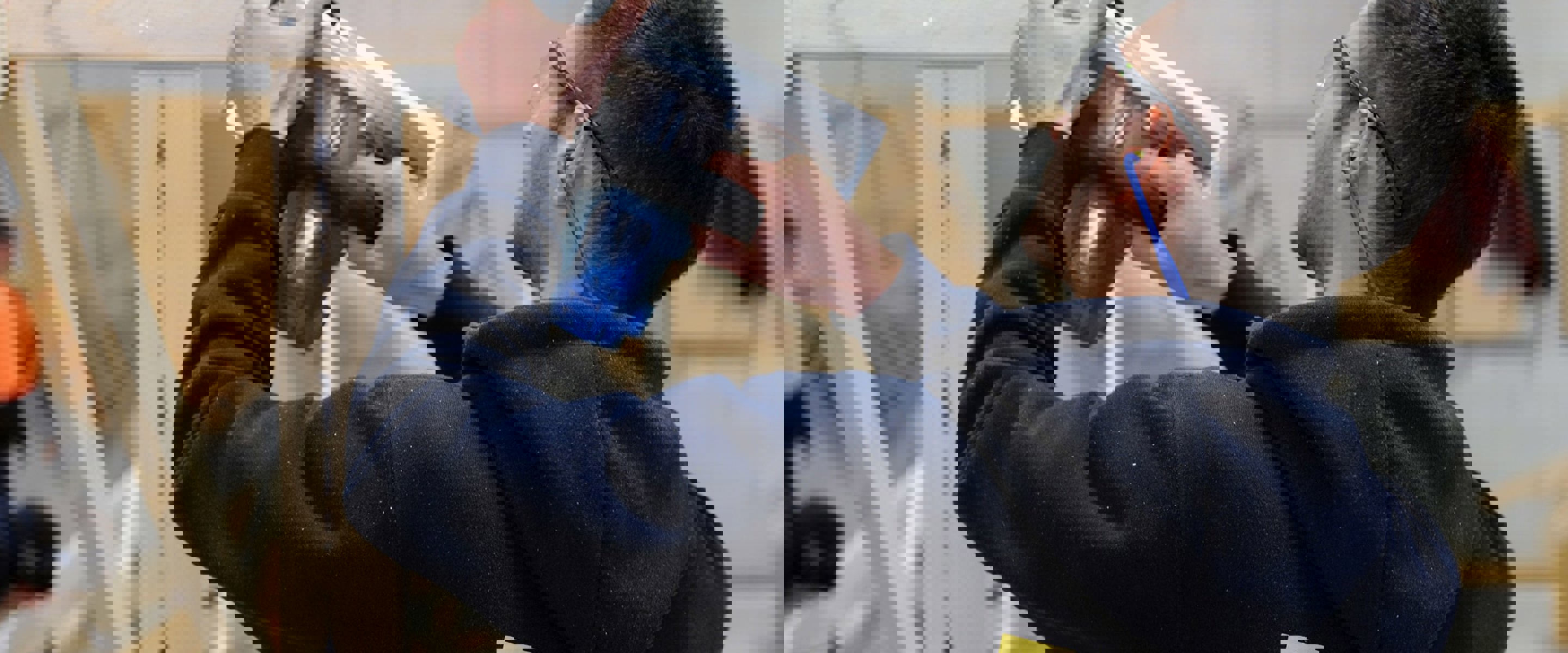 Building Surveying and Construction student with using a hand saw on a timber frame