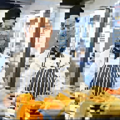 Cookery Studies - Student in kitchen preparing vegetables for roasting