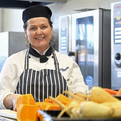 Cookery Studies - Student in kitchen preparing vegetables for roasting