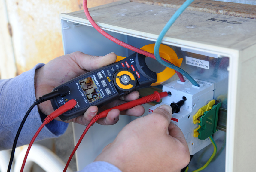 Electronics and Electrical student testing a fuse box with electronic device