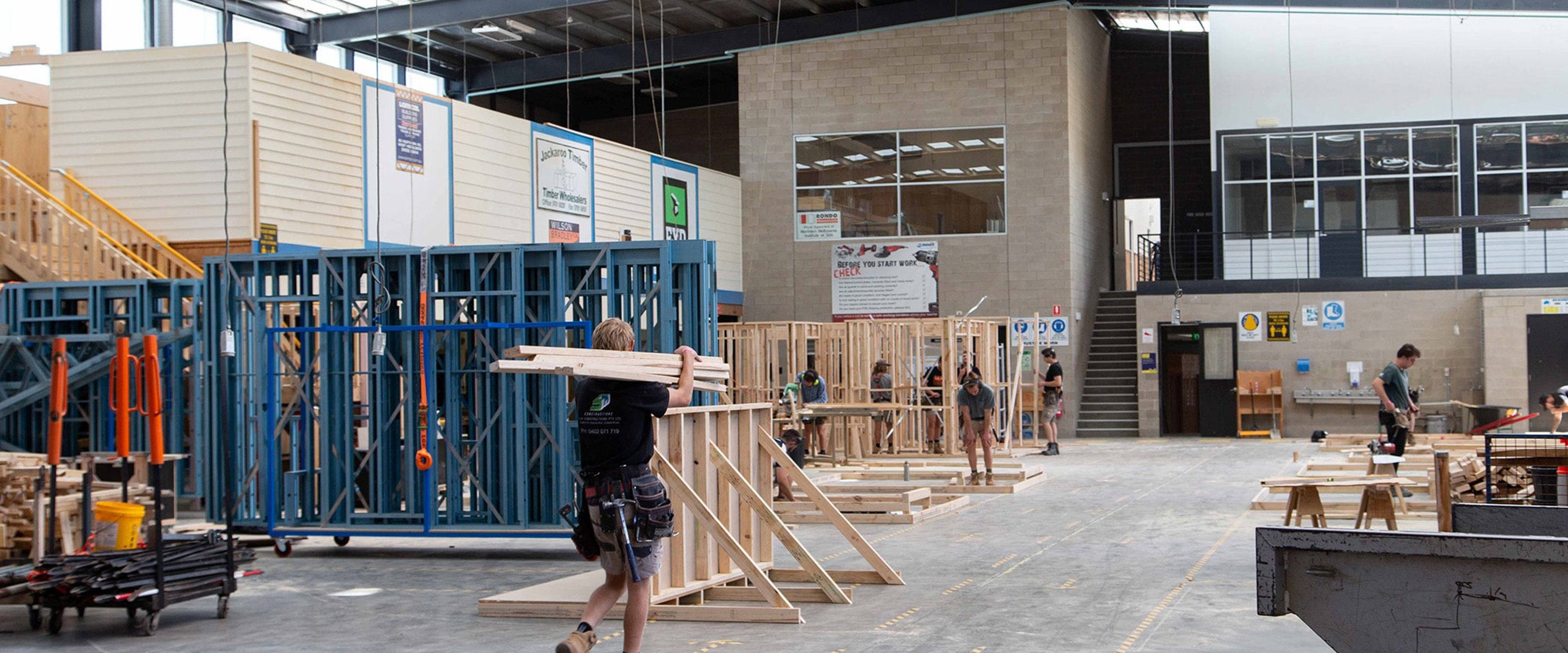 Heidelberg campus Construction students working in outdoor practical study area with steel and timber building frames