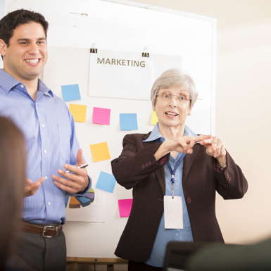 People standing in front of a whiteboard having a marketing meeting