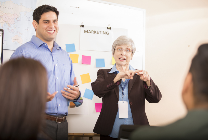 People standing in front of a whiteboard having a marketing meeting