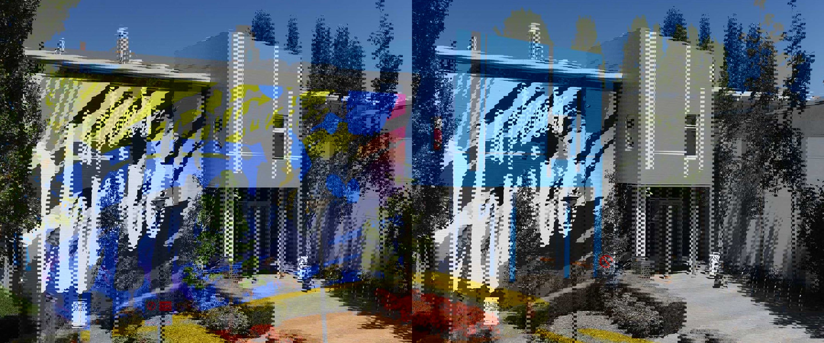 A blue building with a large mural that says "a place to thrive".