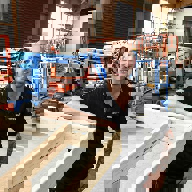 Andrew Guglielmino leaning on a wooden frame in purpose built practical industry enviornment shed on campus