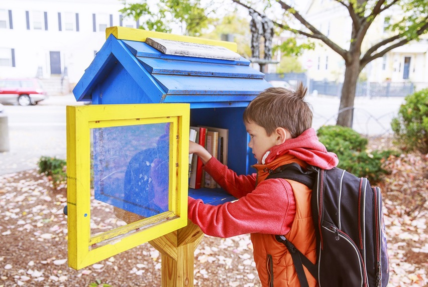 Image of child exchanging books at street library box