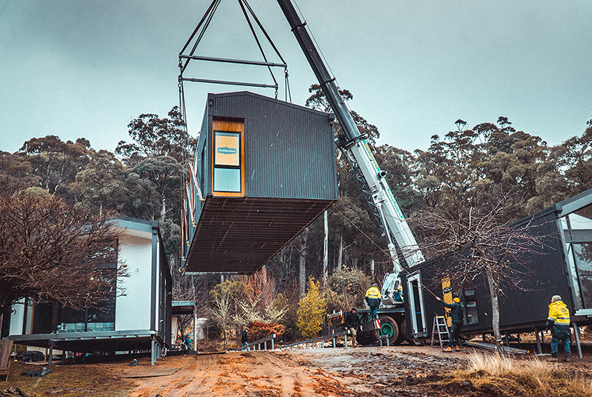 Crane lifting a prefabricated building module into place.