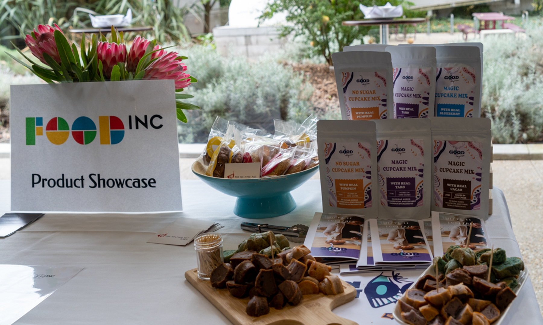 Packaged and baked food products on a table with brochures
