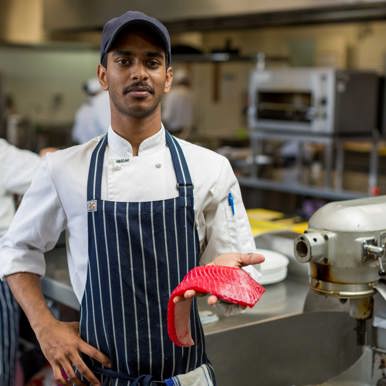 Image of hospitality student holding a fillet of fish