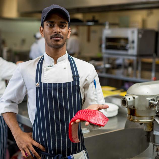 Image of hospitality student holding a fillet of fish