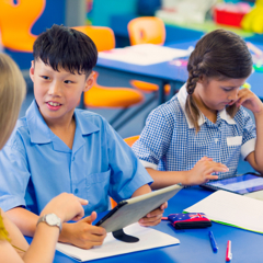 Trade student smiling at camera while holding a Bricklaying and Blocklaying manual.