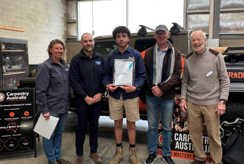 2025 David Provan & Sons Annual Award winner Jerome Gionta standing with members of the Provan and Rosenberg families, all dressed in casual clothing and work boots.