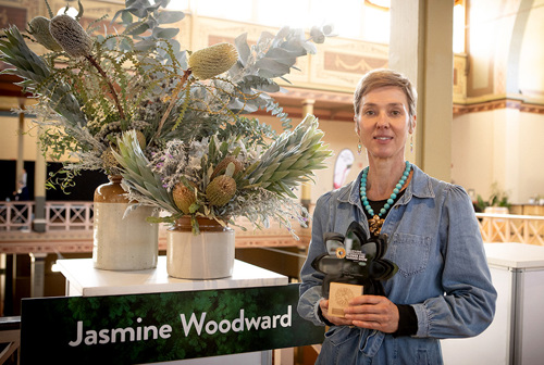 Jasmine Woodward, Open Floral Competition Third Prize Winner, proudly showcases her floral design and trophy.