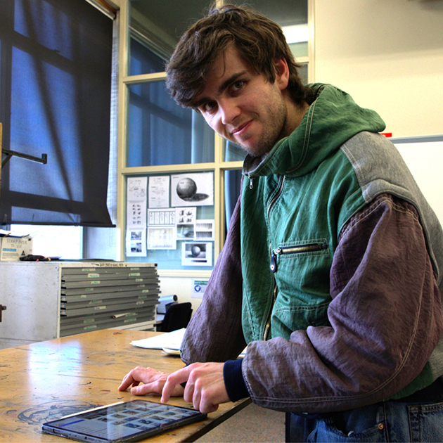 Manuel Morena, student using ipad in an art studio classroom.