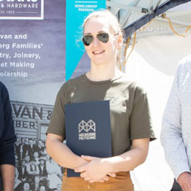 Blonde woman smiling at the camera, wearing sunglasses and holding a Melbourne Polytechnic folder.